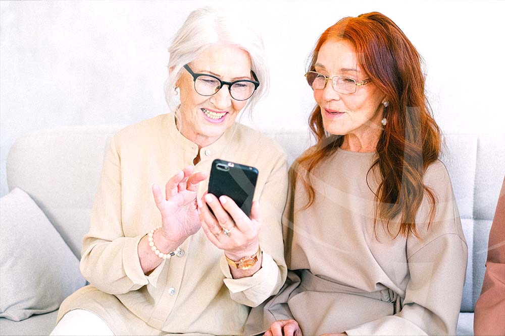 Two women taking care of their investments with a smartphone